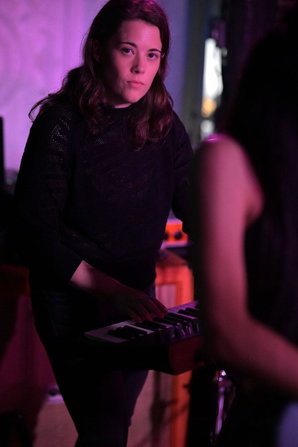 Saray playing keys live under purple lights